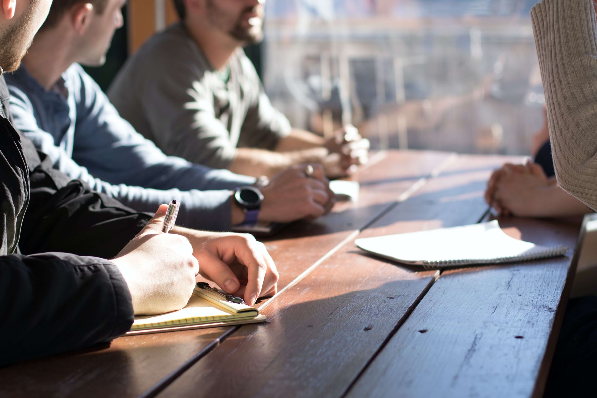 Team members talking to each other while sitting at a desk