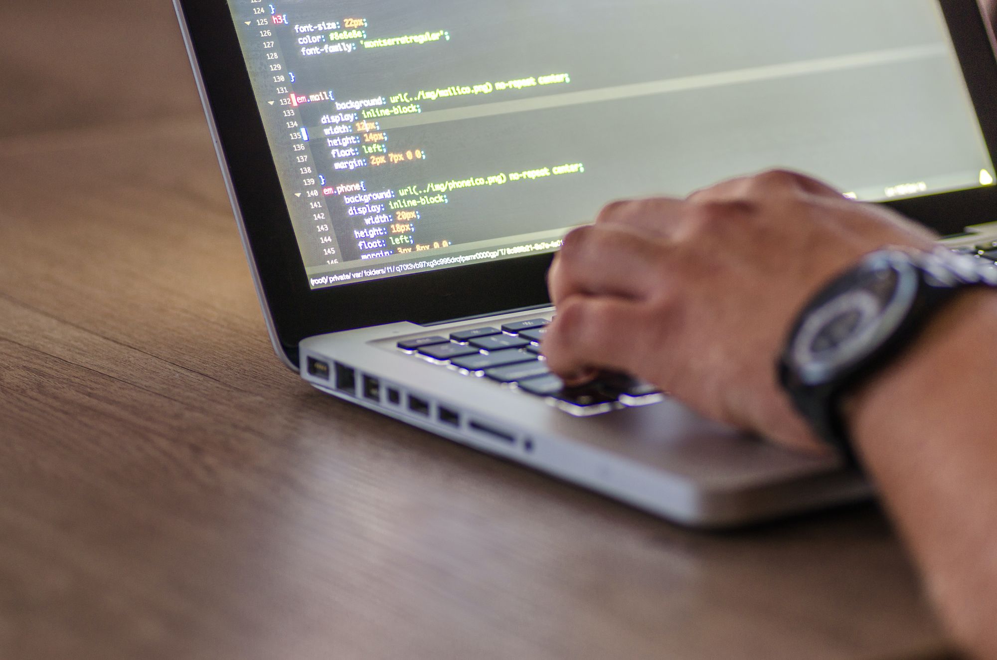 person working on laptop with code on screen