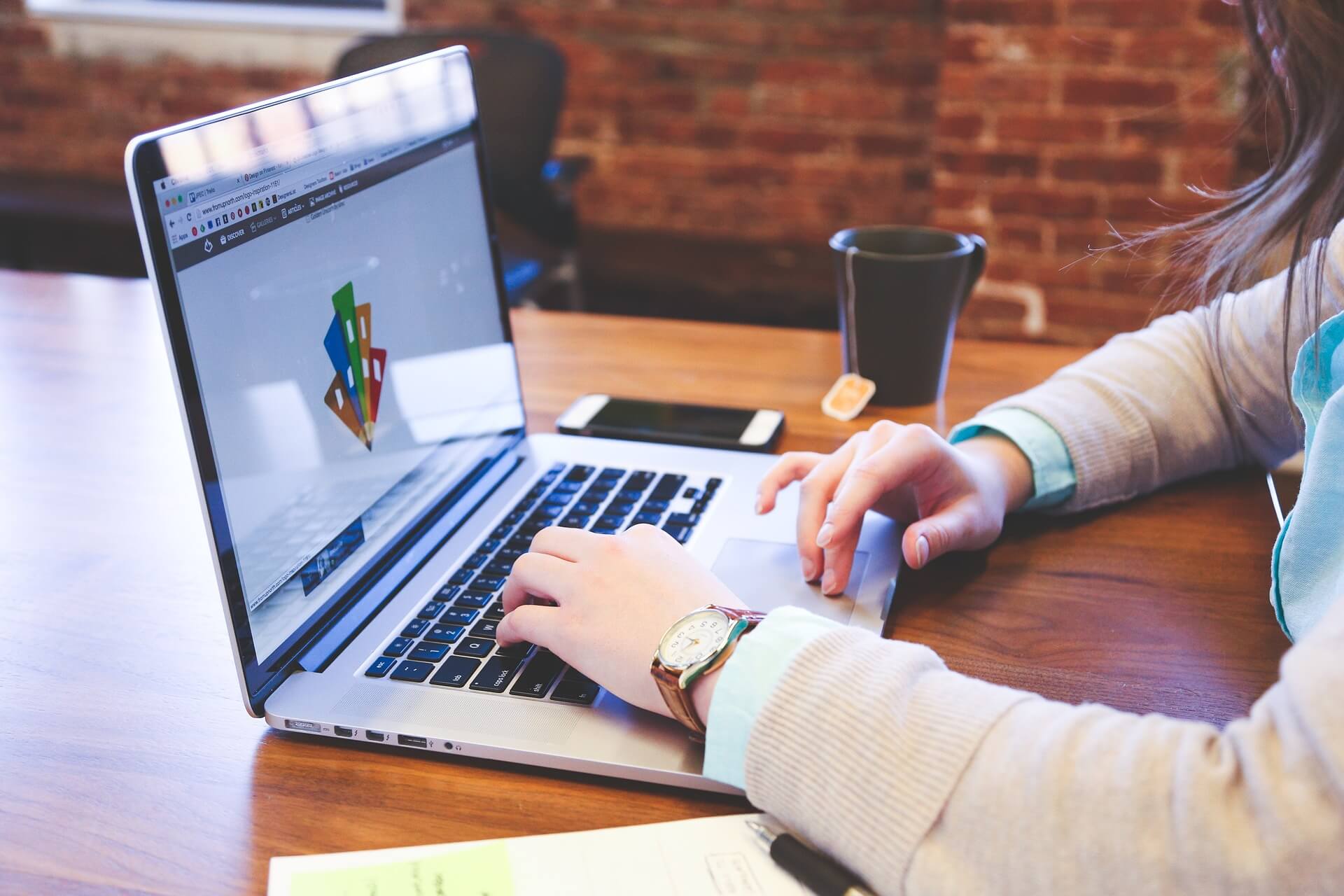 woman working on laptop (branding) sitting at her desk