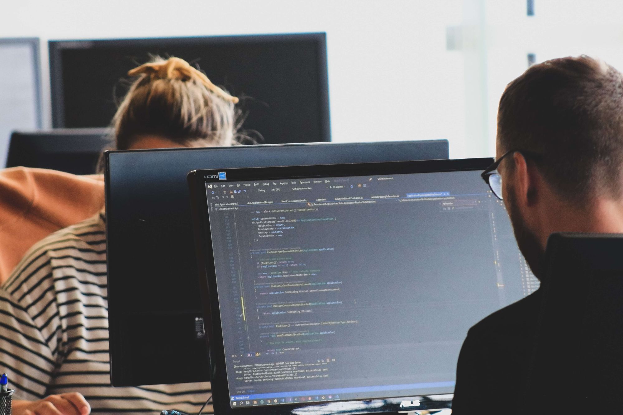 developer sitting in front of each other, coding